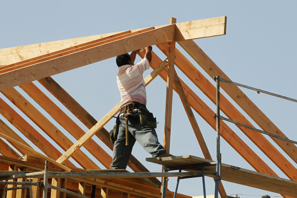 Image: A construction worker works on the framework for a single family home currently under construction in Los Angeles