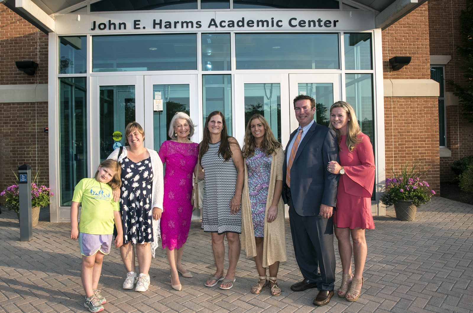 Family members, including, from left, Taylor Ann Bowen, Julie Bowen, Marianne Harms, Peggy Denton, Jennifer Lund and Gordon Buchanan and Courtney Buchanan, stand in front of the newly named John E. Harms Academic Center at CSM’s Prince Frederick Campus.